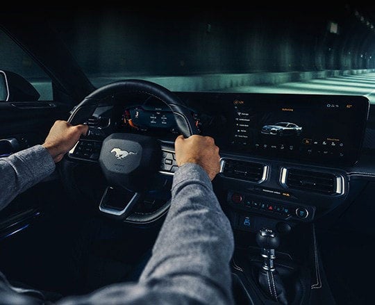 A 2024 Ford Mustang® model interior with a person driving | Harbin Motor Company in Scottsboro AL